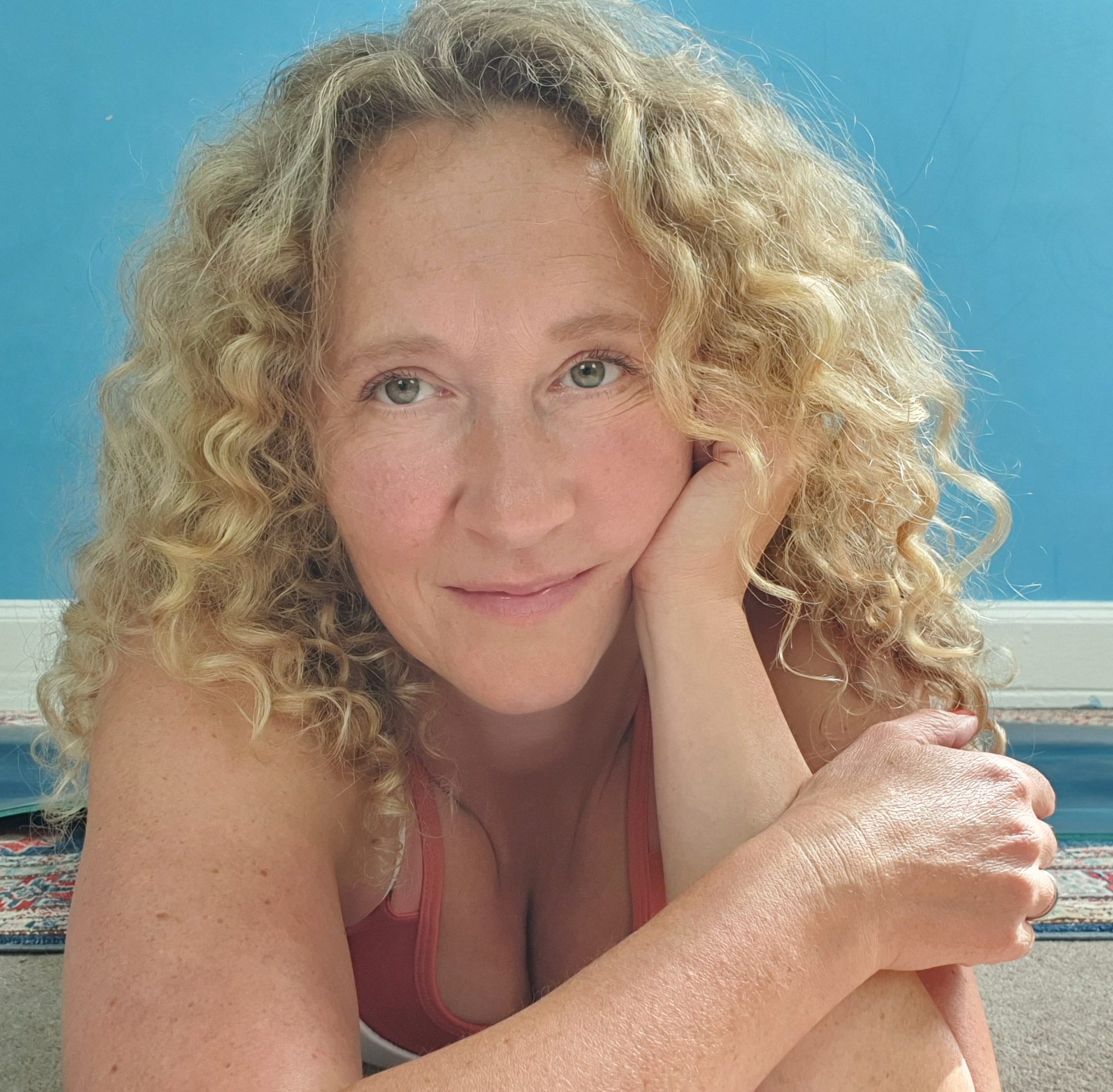 Curly & scattered haired sexy white woman lying on the beach of the ocean feeling better after doing a massage
