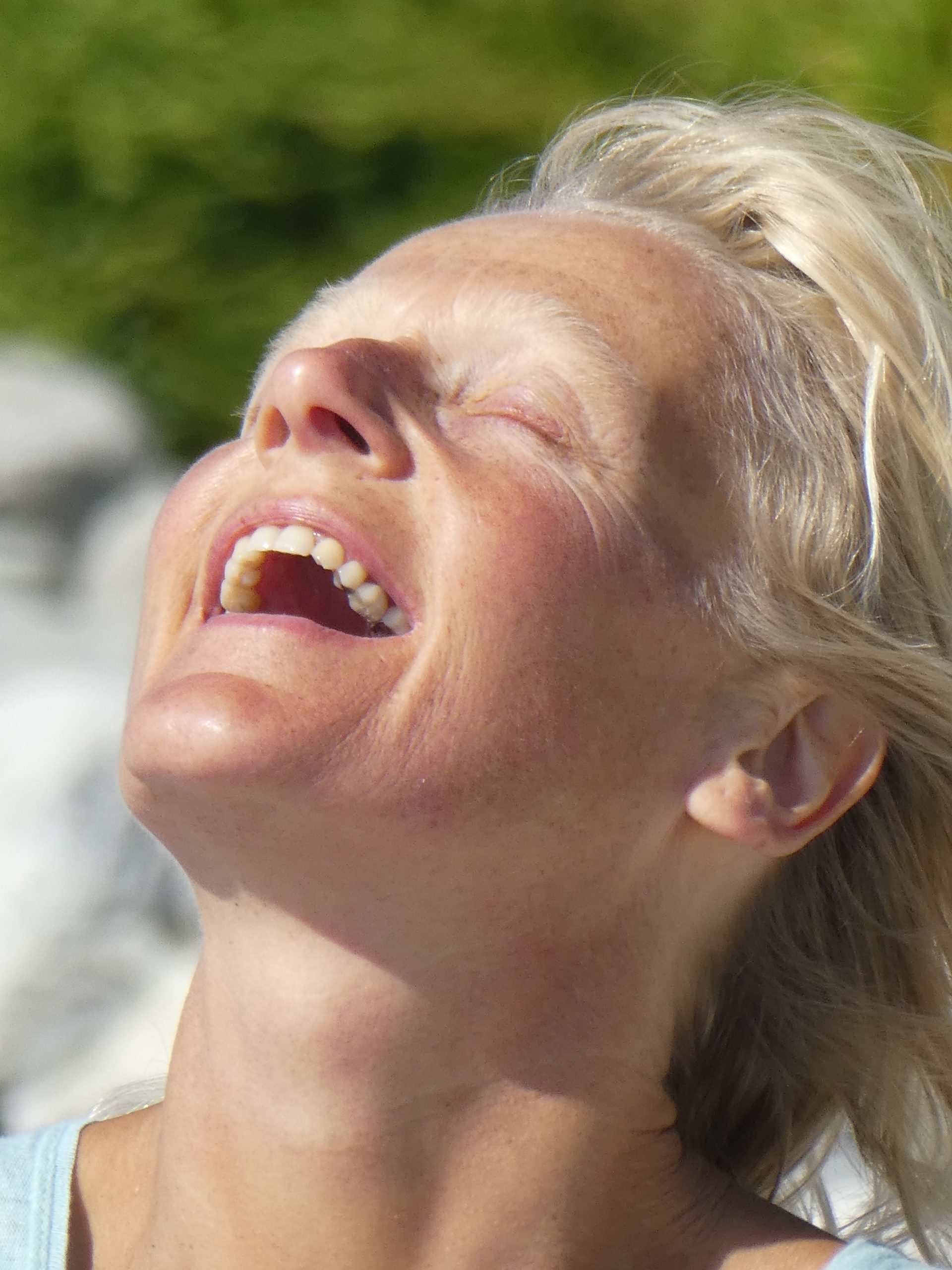 A white-haired woman faces upward to the sky, feeling happy after doing a yoga