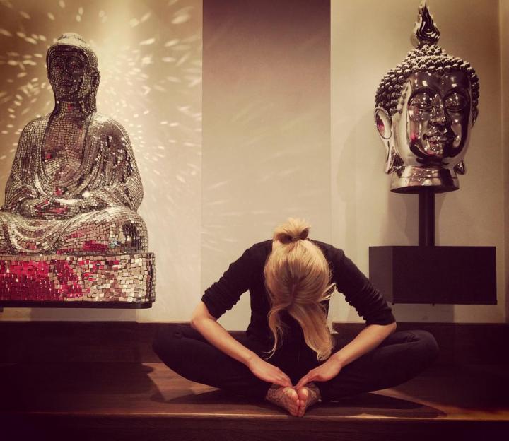 A young girl with her downward face sitting from Meditating Thai Buddhist Altar & Modern Day Yoga