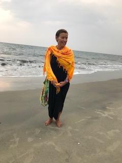 A very happy woman holding hands on the beach of the ocean