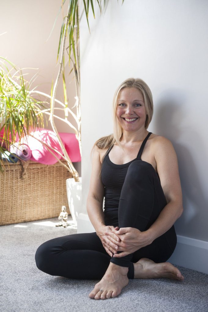 She has a beautiful smile sitting on the ground, with Yoga asana black silhouette lotus and basket