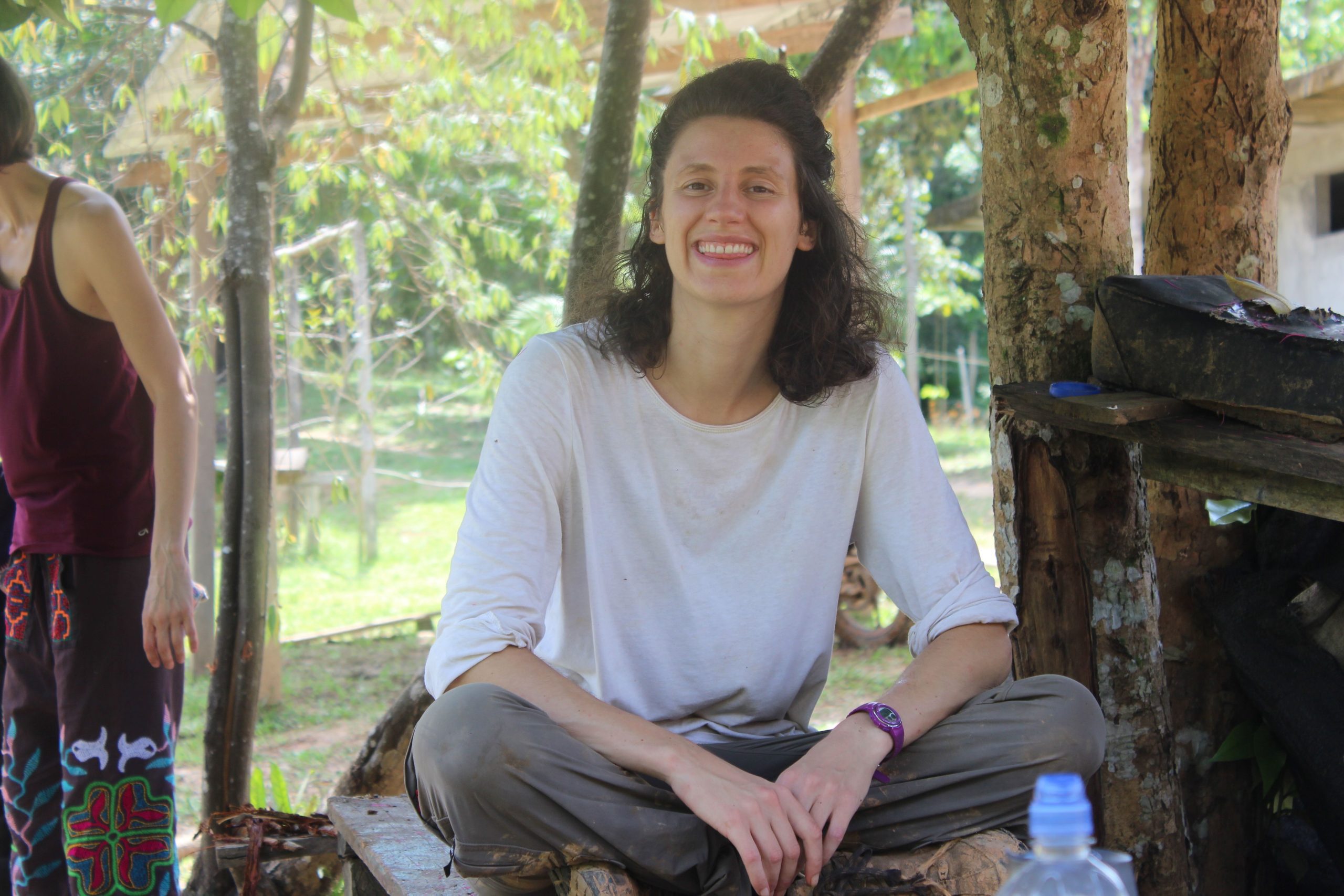 Smiley woman sitting at the table surrounded by the multiple tree background