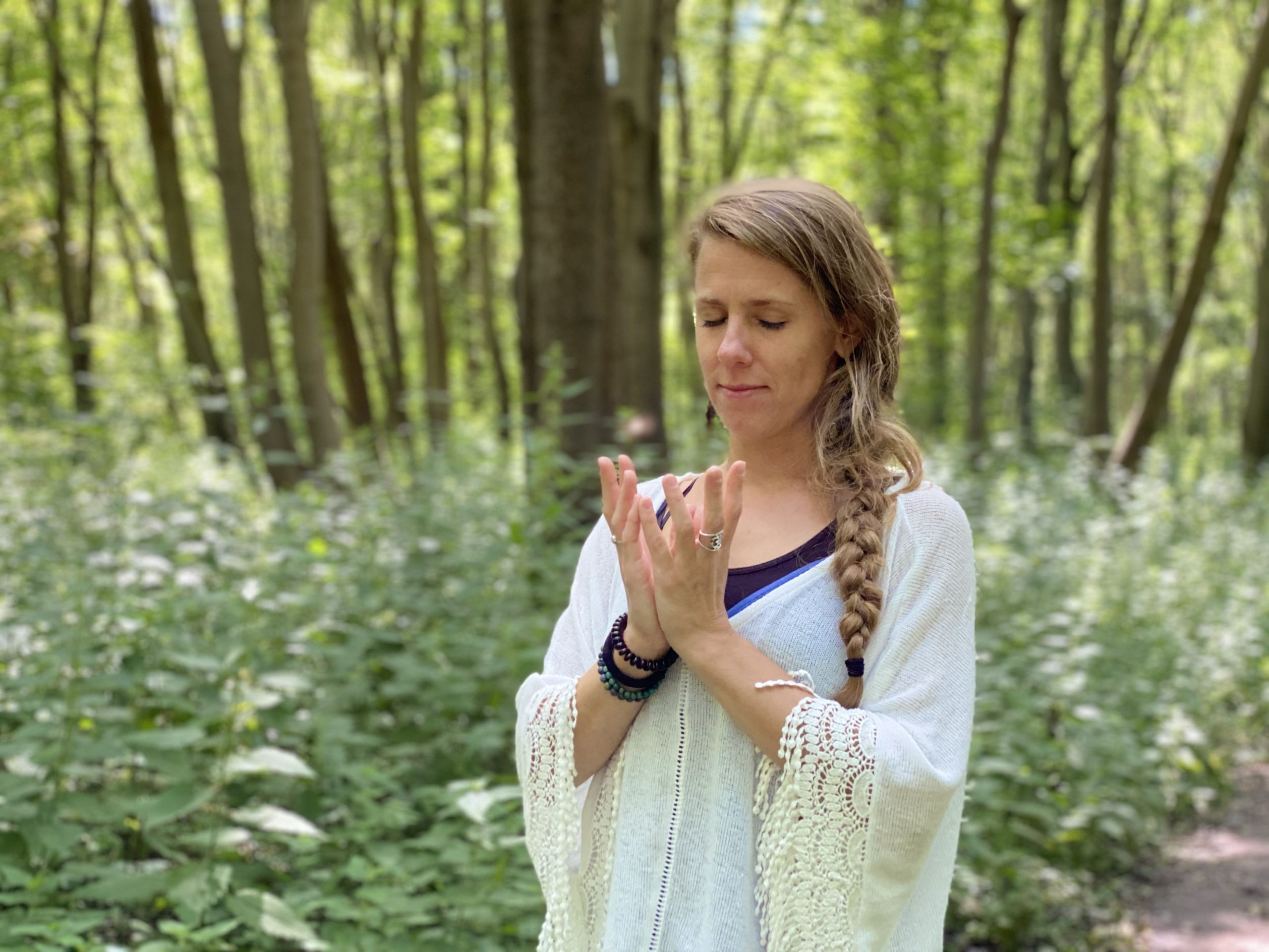 A slim girl standing in the forest with the Therapeutic & transformative yoga pose