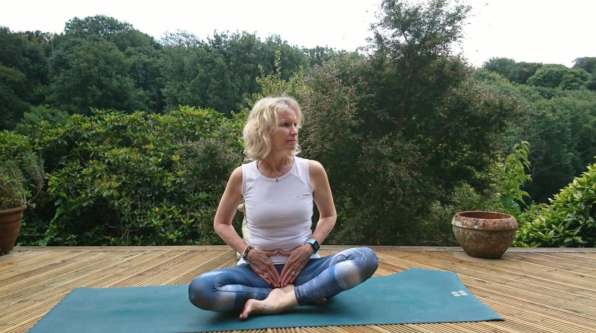 The old woman sitting in Meditation & Yin Yoga sequence for hips pose, surrounded with their background is trees