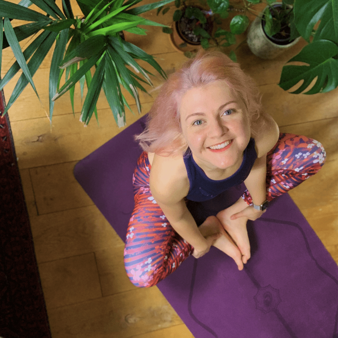 The brown-white-haired attractive girl sitting in Easy Pose on a mat